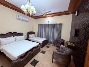 une chambre avec un lit, un canapé et une chaise dans l'établissement Clift Royal In, à Islamabad