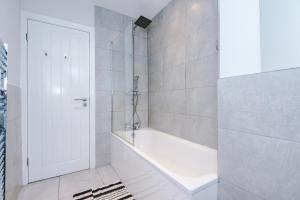a bathroom with a white tub and a white door at Contractor, Relocation, insurance , 4 bedrooms, Bury in Bury