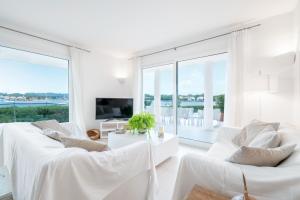 a white living room with white furniture and large windows at Villa Can Marilla in Felanitx