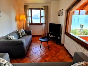 Una sala de estar con un sofá y un televisor. en Appartamenti Il Medeghino, en Musso