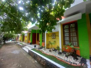 a yellow and green house with plants in front of it at Casa Felicisima Inn in Puerto Princesa City +34 photos