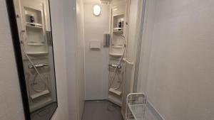 a bathroom with a row of walk in showers at Hotel Galaxy Pod 本川越店 in Kawagoe +68 photos