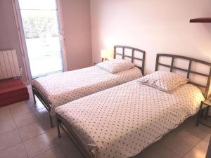 Dos camas individuales en una habitación con ventana. en Superbe Appartement 2 Chambres, en La Ciotat
