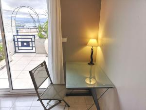 Una mesa de cristal y una lámpara en una habitación con balcón. en Superbe Appartement 2 Chambres, en La Ciotat 8 fotos más