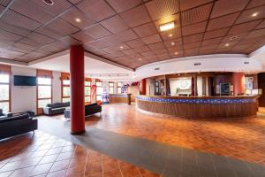 a lobby of a hotel with a bar and couches at Villages Clubs du Soleil - ARC 1800 in Arc 1800