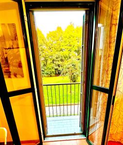 an open glass door with a view of a yard at TT House Rho Fiera Milano Station in Rho