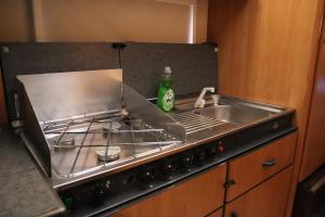 a kitchen counter with a sink and a stove at Full Service Caravan 3 in Søborg
