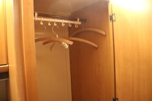 a bathroom with a mirror and a closet with hangers at Full Service Caravan 3 in Søborg