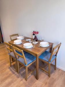 a wooden table with chairs and plates and glasses at #22, Free parking, Self check-in, Perfect location for Katowice, Chorzow, and DTS, 3rd floor - no elevator in Chorzów