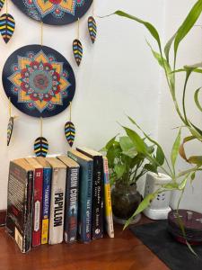 a group of books on a shelf with plates on a wall at Sea Breeze Bay in Calangute