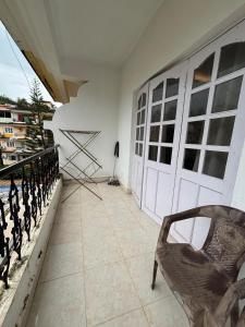 a balcony with a chair and a white door at Sea Breeze Bay in Calangute