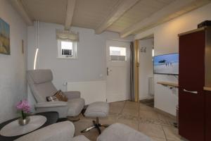 a living room with chairs and a flat screen tv at Appartement Rehder in Hörnum