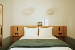 Un pat sau paturi într-o cameră la Hôtel Casimir