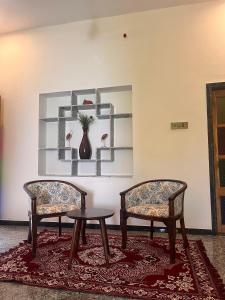two chairs and a table in a room with shelves at Chitrak stays Jawai in Bijāpur