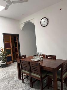 a dining room with a table and a clock on the wall at Chitrak stays Jawai in Bijāpur