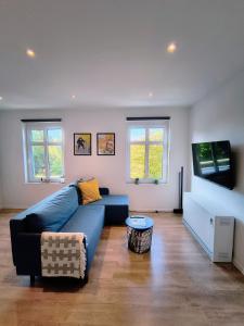 a living room with a blue couch and a flat screen tv at #22, Free parking, Self check-in, Perfect location for Katowice, Chorzow, and DTS, 3rd floor - no elevator in Chorzów