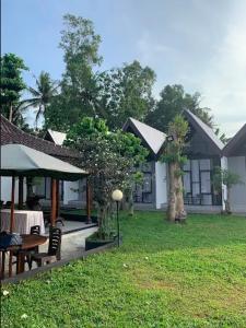 une maison avec une table et des chaises dans une cour dans l'établissement Homestay Alenay Resort Kulonprogo, à Brosot