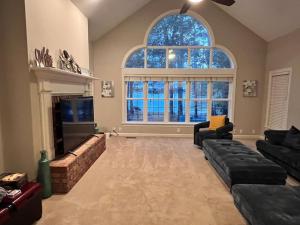 een woonkamer met een bank en een groot raam bij Modern 3br Lake front home in Johnsonville