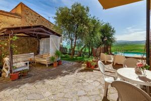 a patio with a table and chairs and a pool at Casa Chopin - ToscanaOneHH in Laiatico