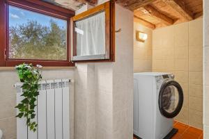a laundry room with a washing machine and a window at Casa Chopin - ToscanaOneHH in Laiatico