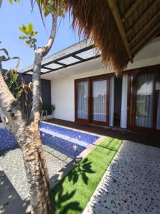una casa con piscina e una palma di villa sawah kolam renang privat a Godean