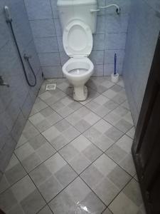 a bathroom with a toilet and a tiled floor at La Grande Cosy 1 Bedroom Ensuite Mtwapa in Mtwapa