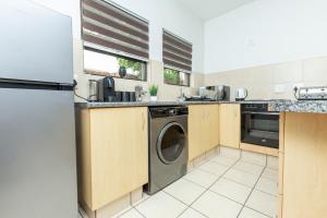 Una cocina con lavadora y secadora. en Sandton Luxury Apartment, 82 Via Arrezio, en Johannesburgo