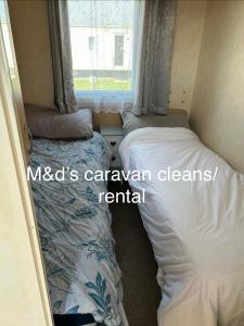 a small room with two beds and a window at Golden palms meadow view in Chapel Saint Leonards