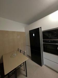 a small kitchen with a table and a black refrigerator at Casinha da Montanha - Paraíso 7 in Ribeira Brava