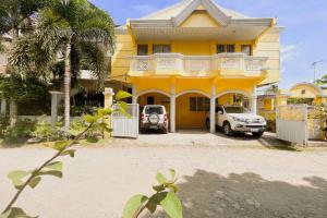 ein gelbes Haus mit davor geparkt in der Unterkunft Iloilo Transient Rooms in Iloilo City