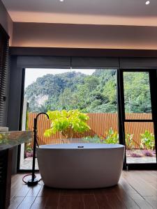 a large bath tub in a room with a large window at Tambuna Retreat ,TAMBUN ,IPOH in Tambun +7 photos