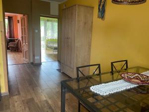 a living room with a glass table and a cabinet at Apartament Ciśnianka in Cisna