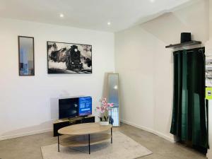 a living room with a table and a tv at Cosy T2 CLIM FIBRE Centre ville RDC in Marmande