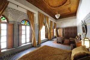 una camera da letto con un letto grande e finestre di Riad Au 20 Jasmins a Fes