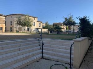 a set of concrete stairs with metal hand rails at Cosy T2 CLIM FIBRE Centre ville RDC in Marmande