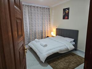 a bedroom with a bed and a window at Pofu Stay Eldoret in Eldoret