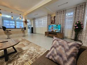 a living room with a couch and a tv at Pofu Stay Eldoret in Eldoret
