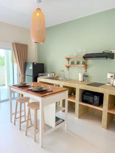 een keuken met een tafel en krukken in een kamer bij The Palm Villa in Ban Ai Dao