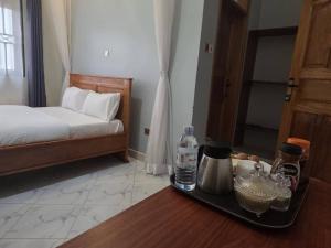 a room with a bed and a table with a tray of food at Gibson Motel in Mbarara +2 photos