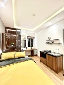 1 dormitorio con 1 cama amarilla y cocina en Salux Hotel, en Da Nang