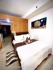 a bedroom with two beds and a picture on the wall at Staycation Near Mall of Asia in Manila