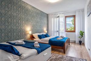 una camera da letto con due letti e una finestra di Apartmán KaTry a Veľká Lomnica Altre 19 foto