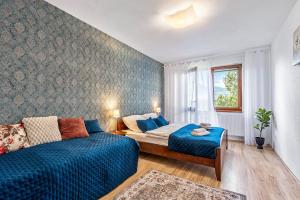 een slaapkamer met een bed, een bank en een raam bij Apartmán KaTry in Veľká Lomnica +20 foto's