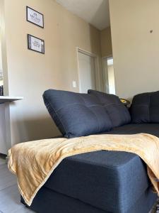 a blue couch with a blanket on top of it at MicasaKollections - Villa Ndahafa in Ongwediva