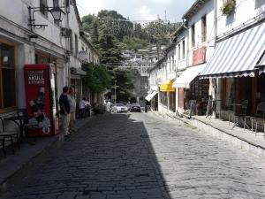 una calle adoquinada de piedra en una ciudad con edificios en Tina's Apartment, en Gjirokastra