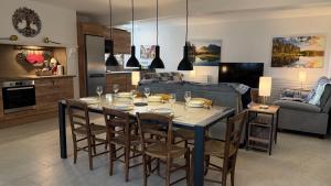 Una mesa de comedor con sillas y una cocina. en Chaintre La Ferme, en Château-Chinon 33 fotos más