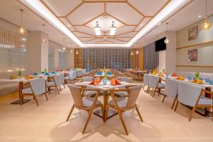 a banquet hall with tables and chairs in a restaurant at Park Inn by Radisson Lucknow Vikas Nagar in Lucknow