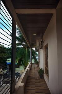a walkway outside of a building with a balcony at Shukra Homestay Hampi,kaddirampura in New Hampi