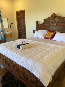 a bedroom with a large bed with a wooden headboard at Shukra Homestay Hampi,kaddirampura in New Hampi