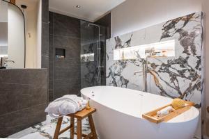 une salle de bain avec une baignoire blanche et une douche dans l'établissement City Core Katerini, Platea Lux, à Kateríni 8 autres photos